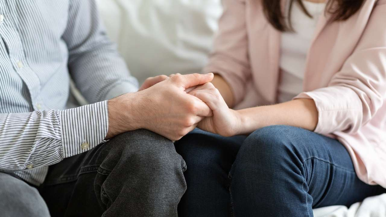 Casal de mãos dadas em sessão de terapia, simbolizando vínculo e conexão